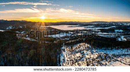 Aerial panorama with frozen Georgetown Lake, near Philipsburg, Montana at sunset. Anaconda range with Warren Peak dominates the background of the winterly landscape.