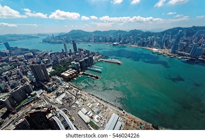 Aerial Panorama Of Hong Kong & Kowloon With City Skyline Of Crowded Skyscrapers By Victoria Harbour & Ships Between Tsim Sha Tsui & Central Ferry Piers ~ Beautiful Cityscape Of Hongkong On A Sunny Day