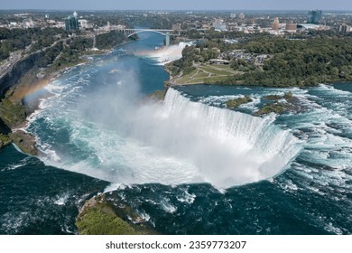Aerial panorama of huge water flows down the waterfall, Horseshoe Water Fall in Niagara. Skyline of the United States and Canada border.