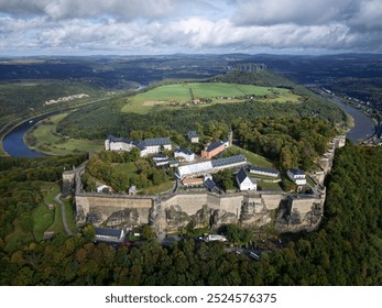 Aerial panorama of majestic Königstein Fortress, aka the Saxon Bastille, which perches on a hilltop overlooking the River Elbe in the beautiful countryside near Dresden, in Saxon Switzerland, Germany - Powered by Shutterstock