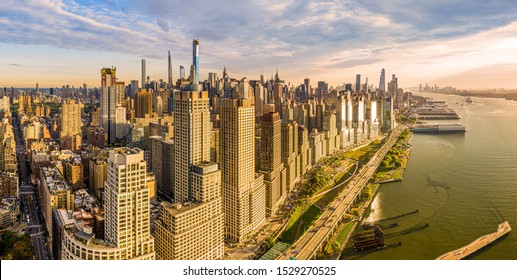Aerial panorama of New York City waterfront skyline at sunset viewed from above River Side Park, along Joe DiMaggio highway and Riverside Blvd, next to Hudson River. - Shutterstock ID 1529270525