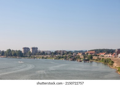 Aerial panorama of the Reka Sava river with the watefront quay in the left and a few boats passing by in Sremska Mitrovica, a city of Vojvodina, in the srem region, in Serbia. 

 - Shutterstock ID 2150722757