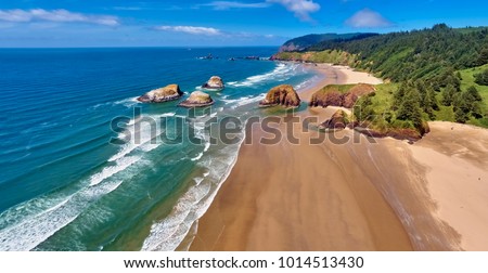 Aerial panorama shot at approximately 350 feet above Cannon Beach looking towards Ecola State Park on a sunny blue sky day on the Oregon Coast