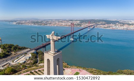 Aerial. Panorama from sky, a 25 de Abril Bridge and a statue of Jesus Christ. Lisbon