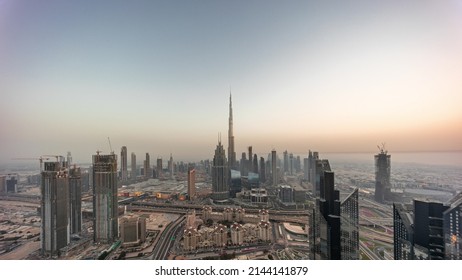 Aerial panorama of tallest towers in Dubai Downtown skyline and highway day to night transition timelapse. Financial district and business area in smart urban city. Skyscraper and high-rise buildings