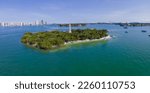 Aerial panorama view of Flagler Memorial Island at Miami Beach, Florida. Island with boats on the shore and waterway against the view of high-rise buildings and sky at the background.