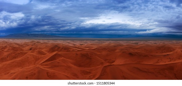 Aerial Panorama View On Sand Dunes With Storm Clouds At Sunset In Gobi Desert, Mongolia