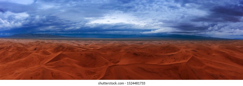 Aerial Panorama View On Sand Dunes With Storm Clouds At Sunset In Gobi Desert, Mongolia