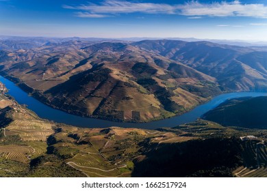 Aerial panoramic drone photograph of the beautiful Douro Valley and the Douro River near the Village of Tua, with the terraced vineayards.