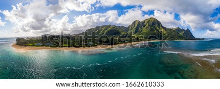 Aerial panoramic image off the coast over Tunnels beach on Hawaiian island of Kauai with Na Pali mountains behind