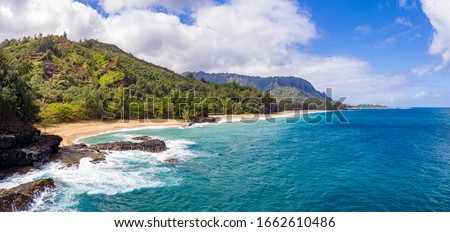 Aerial panoramic image off the coast over Lumaha'i beach on Hawaiian island of Kauai with Na Pali mountains behind