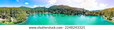 Aerial panoramic over the beautiful El Cedral lake full of visitors rowing small boats wearing life jackets on a sunny day