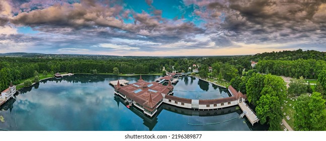 Aerial Panoramic Shot Of Lake Hévíz From Above, Lake Bath With Park And Forest.