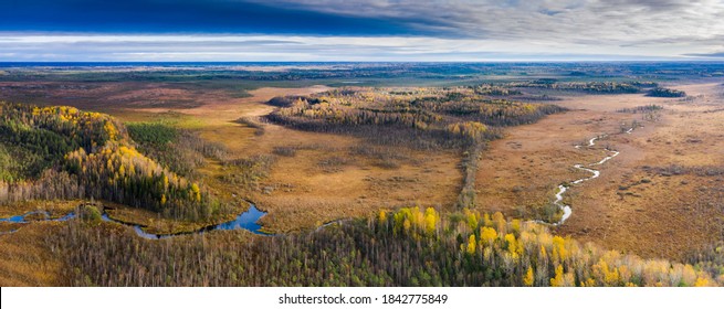 Aerial panoramic view to the autumn colored wilderness landscape with the natural meandering stream on the swampy floodplain, surrounded by post glacial eskers and drumlins,  woodlands and marshes. - Shutterstock ID 1842775849