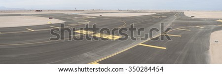 Aerial panoramic view of a commercial airport runway with connections and taxiways