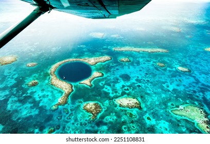 Aerial panoramic view of The Great Blue Hole - Detail of Belize coral reef from airplane excursion - Wanderlust and travel concept with nature wonders on azure vivid filter