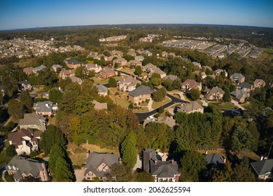 Aerial panoramic view of house cluster in a sub division in Suburbs with golf course and lake in metro Atlanta in Georgia ,USA shot by drone shot during golden hour.
