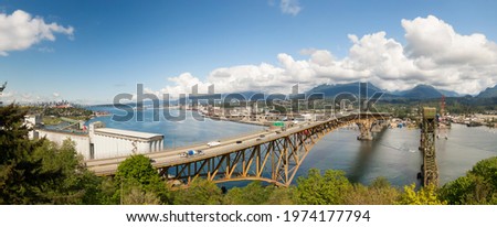 Aerial panoramic view of an Industrial Site and Second Narrows Bridge during a sunny spring day. Taken in Vancouver, British Columbia, Canada.