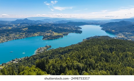 Aerial panoramic view of Lake Wörthersee seen from Pyramindenkogel in Carinthia, Austria. Serene turquoise waters, lush green forests and rolling hills of Austrian Alps. Charming lakeside village - Powered by Shutterstock