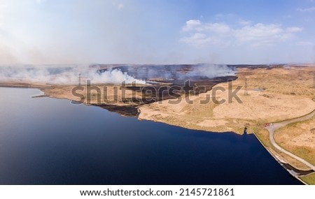 Aerial panoramic view of a large grassfire on moorland in Wales, UK