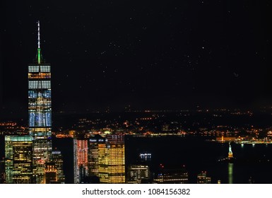 Aerial Panoramic View Of Manhattan Skyline With Statue Of Liberty And Manhattan Bay At Starry Night Sky 