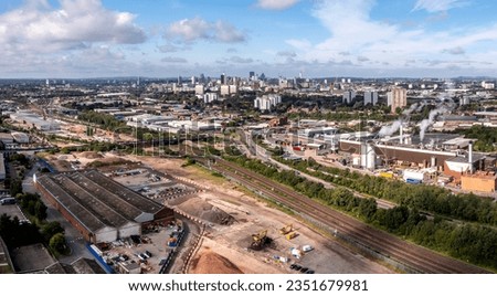 An aerial panoramic view of the new HS2 route and construction site running alongside current railway tracks with a Birmingham city skyline