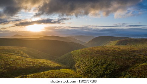 Aerial panoramic view over scenic hills at stormy dramatic sunrise. Shropshire Hills in United Kingdom - Powered by Shutterstock