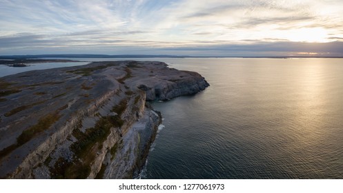 Aerial panoramic view of a rocky Atlantic Ocean Coast during a cloudy sunset. Taken in Burnt Cape Ecological Reserve, Raleigh, Newfoundland, Canada. - Powered by Shutterstock