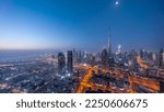 Aerial panoramic view of tallest towers in Dubai Downtown skyline night to day transition  before sunrise. Financial district and business area in smart urban city. Skyscraper and high-rise buildings