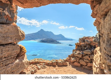 Aerial panoramic view through stone arch of an ancient Venetian castle on the beautiful beach at Balos lagoon ( famous world landmark ). Island of Imeri Gramvousa next to Crete .Chania. Greece. Europe - Powered by Shutterstock