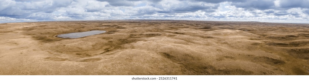 Aerial panoramic view of vast dry prairie cattle grazing land with pond
 - Powered by Shutterstock