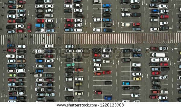Aerial. Parking lots with a\
lot of cars and pedestrian crosswalk between them. Bird eye view\
above. 