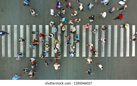 Aerial. Pedestrians passing a crosswalk. Rush hour in the city. People are rushing to work.