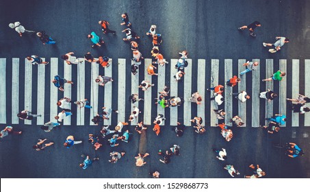 Aerial. People crowd motion through the pedestrian crosswalk. Top view from drone. Toned image.