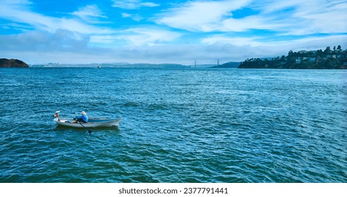 Aerial person rowing rowboat across San Francisco Bay toward Tiburon with Golden Gate Bridge - Powered by Shutterstock