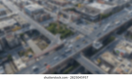 An aerial perspective captures the complex network of a city highway interchange, showing flowing traffic and surrounding urban structures.