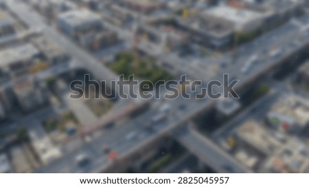 An aerial perspective captures the complex network of a city highway interchange, showing flowing traffic and surrounding urban structures.