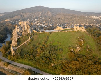 Aerial perspective of Devín Castle in Slovakia. The historic fortress sits atop a rocky hill, with a scenic view of the surrounding landscape and Danube River on sunset. - Powered by Shutterstock