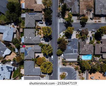 Aerial perspective of a residential area near Mountain View, showcasing a grid of houses, tree lined streets, solar panels, and a backyard swimming pool. - Powered by Shutterstock