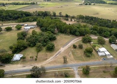 Aerial Perspective Of Small Township Showing Cattle Yards, Show Ring And Homes Bordered By A Creek And The Highway. Finch Hatton, Queensland, Australia.