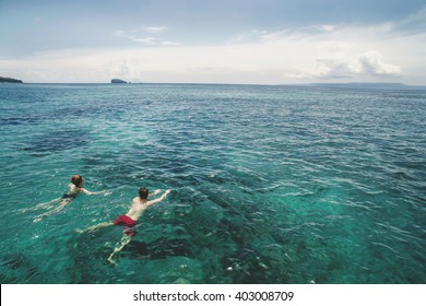 Aerial Photo From Above Of Beautiful Young Couple Swimming In The Ocean At The Tropical Island Beach