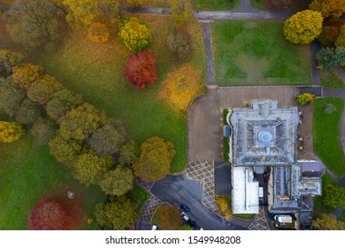 Aerial photo in autumn showing the beautiful autumn colours of a park in Leeds known as Roundhay Park in West Yorkshire UK showing The Mansion Hotel and carpark leading in to the parl.