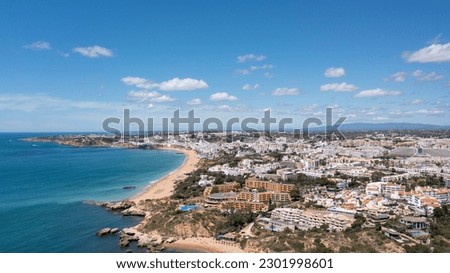 Aerial photo of the beautiful town in Albufeira in Portugal showing the Praia da Oura golden sandy beach, with hotels and apartment in the town, taken on a summers day in the summer time. 