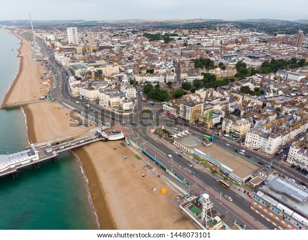 Aerial photo of the Brighton beach and coastal area\
and the famous Brighton pier located in the south coast of England\
UK that is part of the City of Brighton and Hove, taken on a bright\
sunny day