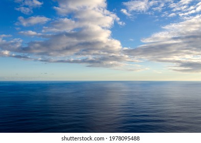Aerial photo of calm tropical Hawaii ocean water with beautiful clouds in the sky