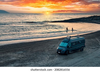 Aerial photo of campervan on abandoned beach against beutiful sunset. People bathing in the sparkling sea. Outdoor nomad lifestyle, van life holiday. Independent road trip concept. - Powered by Shutterstock