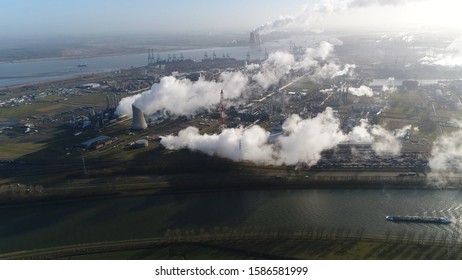 Aerial Photo Of Canal With Barge Moving Over And Heavy Industry In Background Including A Nuclear Power Plant Showing The Generated Steam Which Is Typical With Thermal Stations