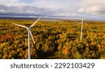 Aerial photo captures the beauty of fall foliage surrounding two towering wind turbines near Mackinaw City, Michigan, showcasing the harmony between nature and renewable energy. Oct 15, 2022