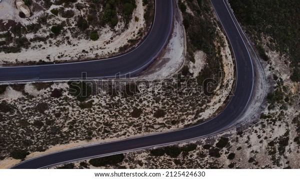 Aerial photo of a\
curved road in a\
mountain
