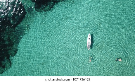 Aerial photo of fit woman paddling on a sup board in caribbean tropical turquoise clear waters